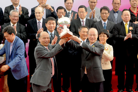 Trainer Joe Lau (left) is presented the trophy by CEO of SJM Dr Amrose So after "The Alfonso" won the 2015 Macau Derby
